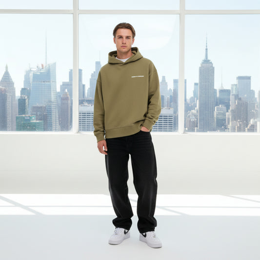 Khaki hoodie with a white chest logo on male model in white studio
