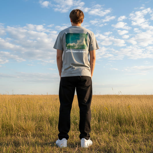 Gray t-shirt with a cloud graphic and 'Little Fluffy Clouds' text on a male model on a field