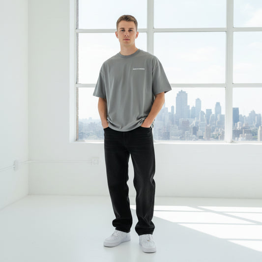 Gray t-shirt with a white chest logo on male model in studio