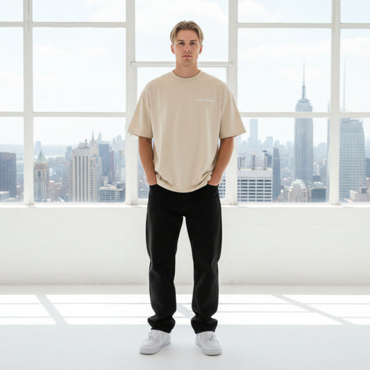 Beige t-shirt with white chest logo on male model in studio