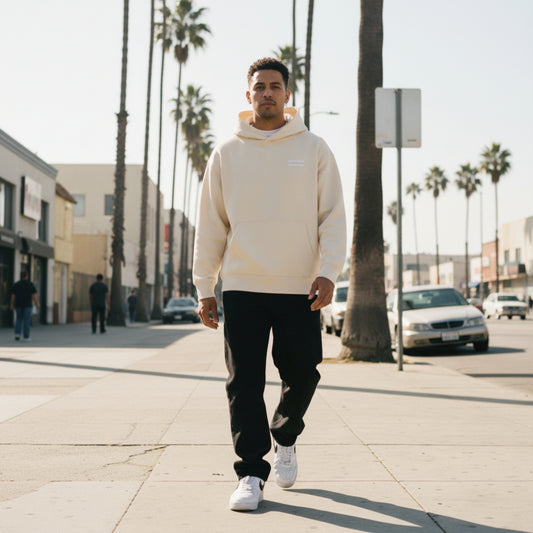 Beige hoodie with a small logo on the chest on male model in LA
