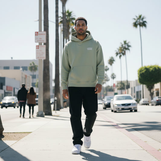Clay hoodie with white text on the chest on male model in LA