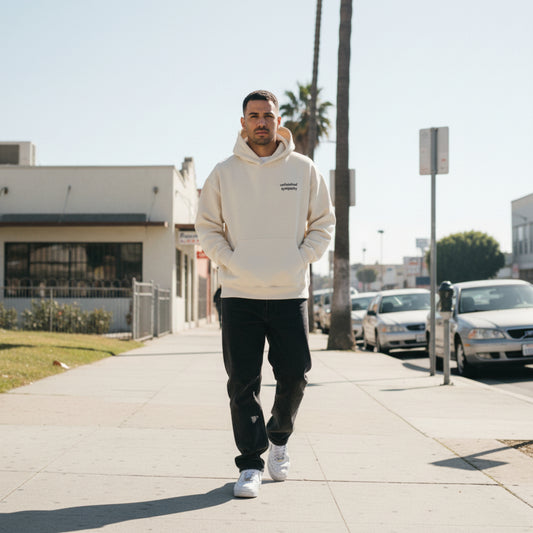 Beige hoodie with 'unfinished sympathy' chest text on male model in LA
